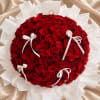 Large round bouquet of red roses with white ribbon bows and wrapping