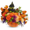 Halloween bouquet in an orange pumpkin container with a haunted house topper