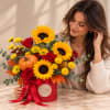 Sunflower and rose arrangement in a red hat box with a pumpkin