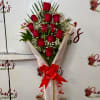Bouquet of red roses with baby's breath wrapped in pink paper and a red ribbon