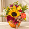Mixed bouquet in a pumpkin container with a plaid ribbon