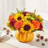 Fall bouquet in a pumpkin-shaped container with sunflowers and roses