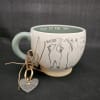 Dog-themed ceramic mug with a heart keychain tied to the handle