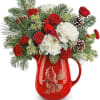 Red and white floral arrangement in a red pitcher vase