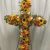 Cross-shaped floral tribute with sunflowers, orange roses, and mixed blooms