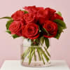 A dozen red roses mounded into a clear glass cylindeer for a