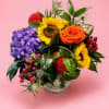 Colorful bouquet with sunflowers, roses, and hydrangea in a glass vase