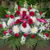 Large red and white floral spray with pink ribbon