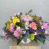 Mixed bouquet in a white basket with pink ribbon and colorful flowers