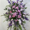 Large standing spray of pink and purple flowers on a metal easel