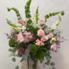 Tall bouquet of pink roses and white snapdragons in a glass vase