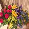 Large mixed floral arrangement with lilies, gerbera daisies, and purple accents