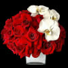 Red roses with white orchids in a clear square vase