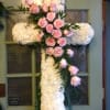 White floral cross with pink roses on a door