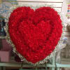 Large heart-shaped red flower arrangement on an easel