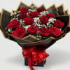 Bouquet of red roses with white baby's breath in black and gold wrapping