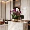 Orchid arrangement in a gold bowl on a marble reception desk