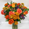 Orange and pink mixed bouquet in a glass vase