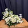 White floral arrangement with lilies and hydrangeas on a wooden table