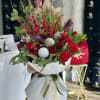 Bouquet of red roses with pine branches, berries, and decorative spheres