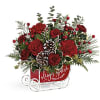 Red floral sleigh arrangement with pinecones and berries