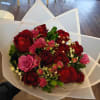 Bouquet of red and pink roses wrapped in white paper