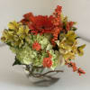 Mixed bouquet with orange gerbera, yellow alstroemeria, and green hydrangea in a glass vase