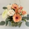 Peach gerberas and cream roses in a glass vase