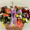 Mixed flower basket with orange roses, daisies, and a purple ribbon