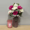 Pink and white daisy bouquet in a polka-dot vase with a ribbon
