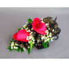 Two pink rose corsages with black ribbon and white filler flowers