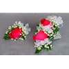 Two rose corsages with white ribbon and baby's breath