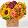 Bouquet of sunflowers, roses, and mums in a leaf-patterned vase