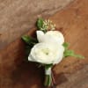 Small white flower boutonniere with green accents