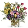 Colorful spring bouquet in a clear glass vase with decorative eggs