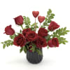 Red roses in a black vase with two glitter heart picks