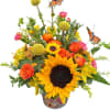 Sunflower and orange rose arrangement in a decorative vase with butterfly picks