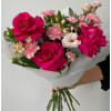 Large hot pink roses steal the show in this birthday bouquet, their