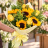 Bouquet of yellow sunflowers and roses wrapped with a yellow ribbon
