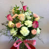 Bouquet of pink and cream roses with carnations in a glass vase