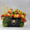This vibrant luxury arrangement overflows fresh seasonal blooms in warm sunset tones.