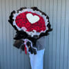 Large bouquet of red roses with a white heart accent and black wrapping