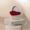 A lush heart-shaped cluster of deep red roses arranged in a white