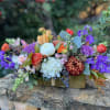 A long and low beauty arranged in a gold rectangular container filled