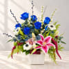 Blue roses and pink lilies in a white vase with mixed blooms