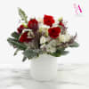 Red roses and white flowers arranged in a white vase
