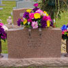 Colorful floral cemetery arrangement around a gravestone