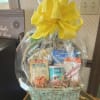 Gift basket with assorted snacks wrapped in clear cellophane and topped with a yellow bow