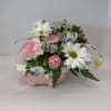 Pink and white flowers arranged in a pink basket-shaped container