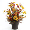 Artificial sunflower arrangement in a black pot with autumn leaves and berries